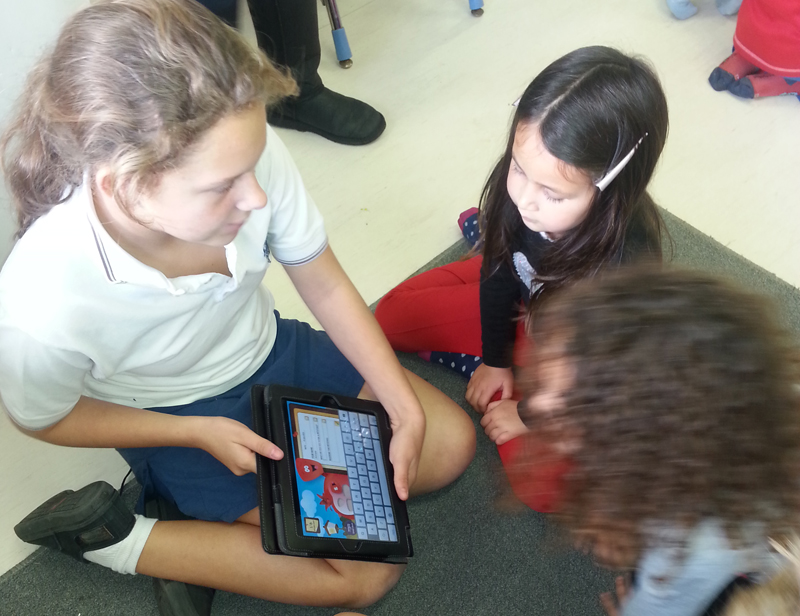 Grade 6 and Grade R playing Mitzvah Hunt together  on iPads